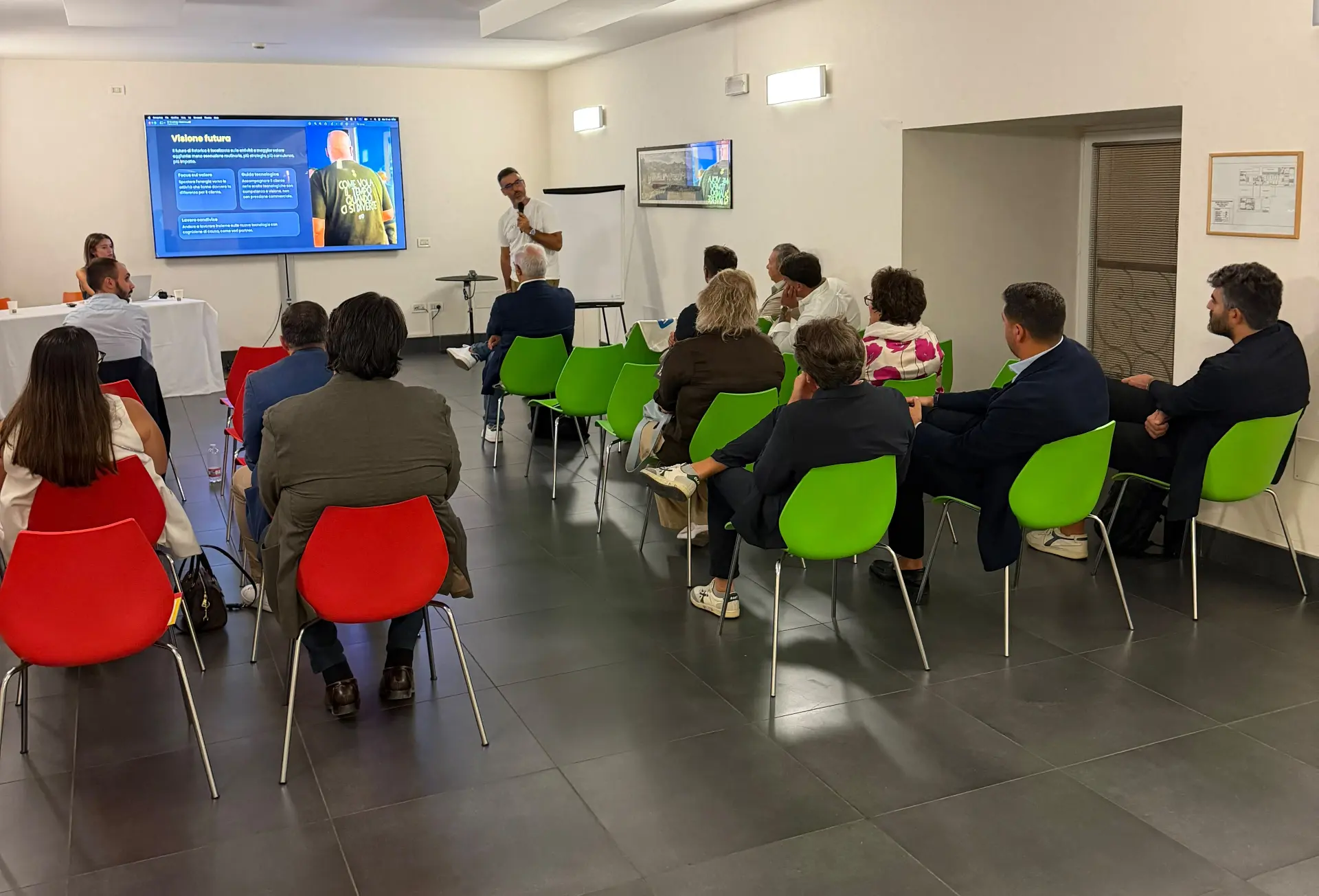 Tappa di Napoli: un relatore con il microfono presenta alla platea in sala
